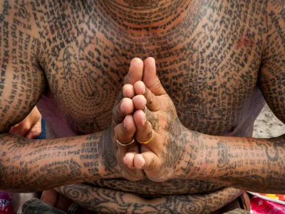 A tattooed devotee prays at the annual tattoo festival at Wat Bang Phra in Nakhon Pathom, Thailand.