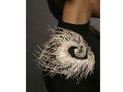 The spiraled crafted work&nbsp;On the Air&nbsp;by Jeong Ju Lee is made to&nbsp;flow with the contour of the model&#39;s shoulder.
