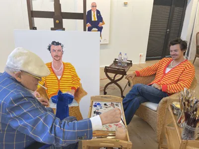David Hockney paints the portrait of Harry Styles that is currently on display in the exhibition.