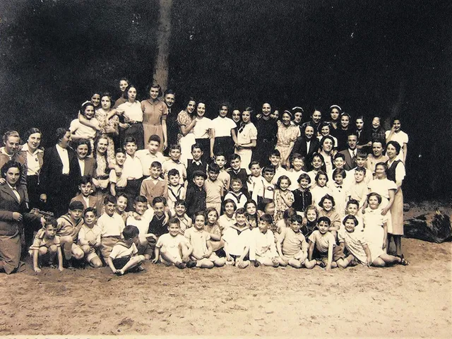 Child refugees from Germany and Austria at the Amsterdam Burgerweeshuis orphanage. Truus Wijsmuller stands at far left, looking at the children she helped save.