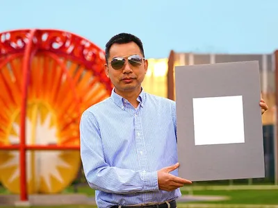 Xiulin Ruan, a Purdue University professor of mechanical engineering, holds up his lab’s sample of the whitest paint on record.